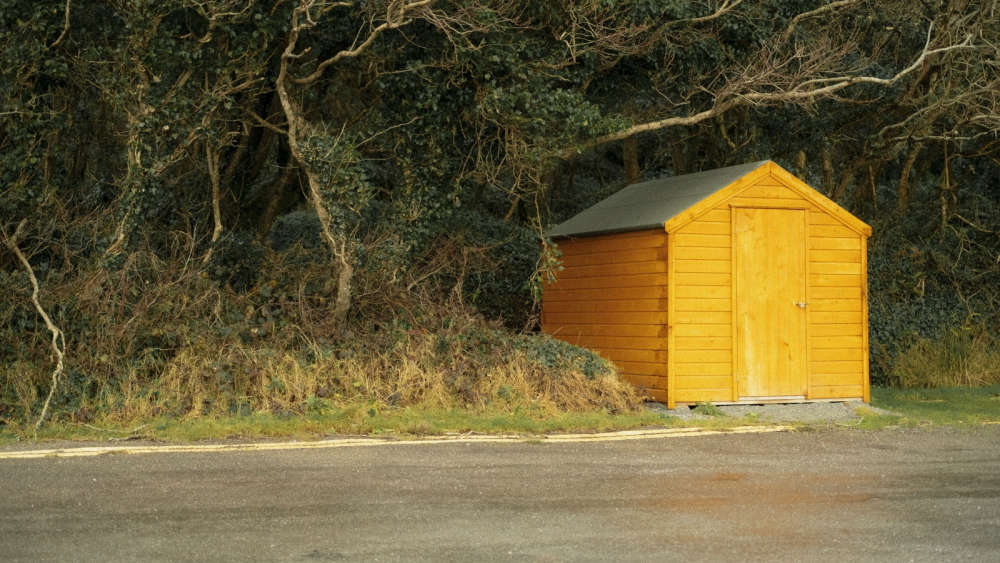 A yellow shed on the side of the road