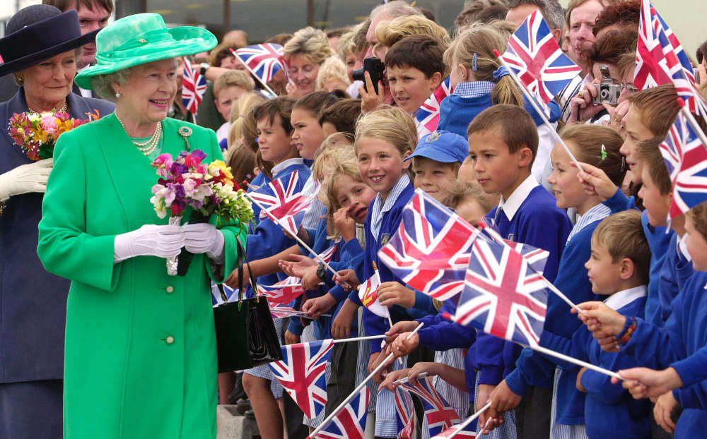 July 2001: The Queen was greeted by schoolchildren at Guernsey Airport at the start of a two day state visit to the Channel Islands. Wearing an apple green outfit, the Queen acknowledged the waiting crowds with a royal wave and a smile.
