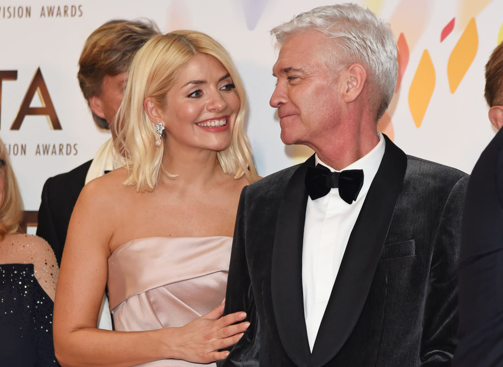 Holly Willoughby and Phillip Schofield look at each other and smile on the red carpet at the National Television Awards.