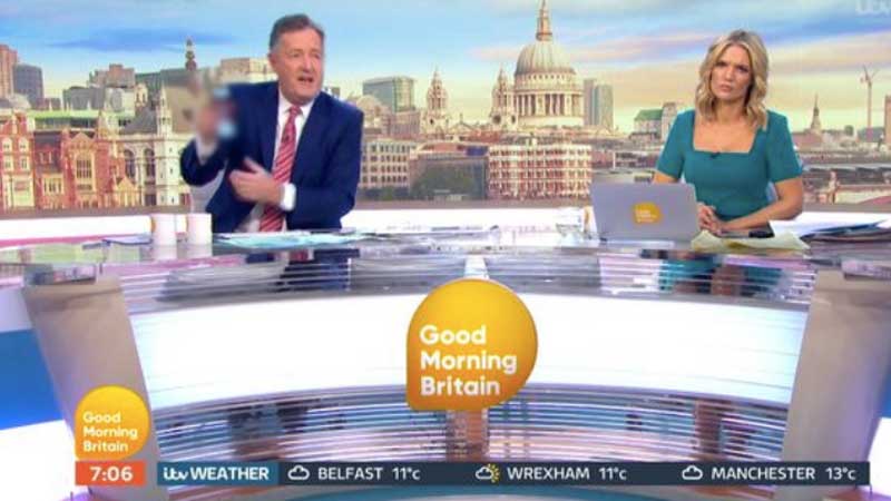 Piers Morgan holding up his phone, showing the image in question. We have blurred the image itself out.