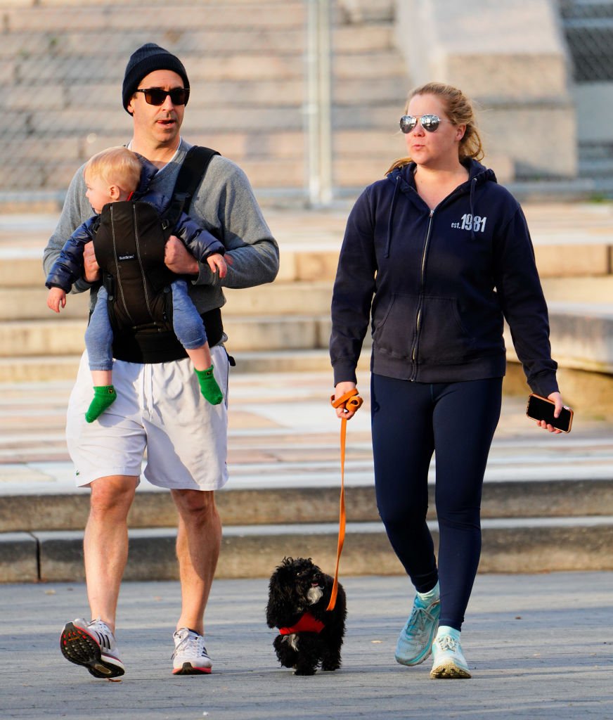 Amy Schumer and husband  husband Chris Fischer take a walk in the park with their son Gene Fischer and the family dog