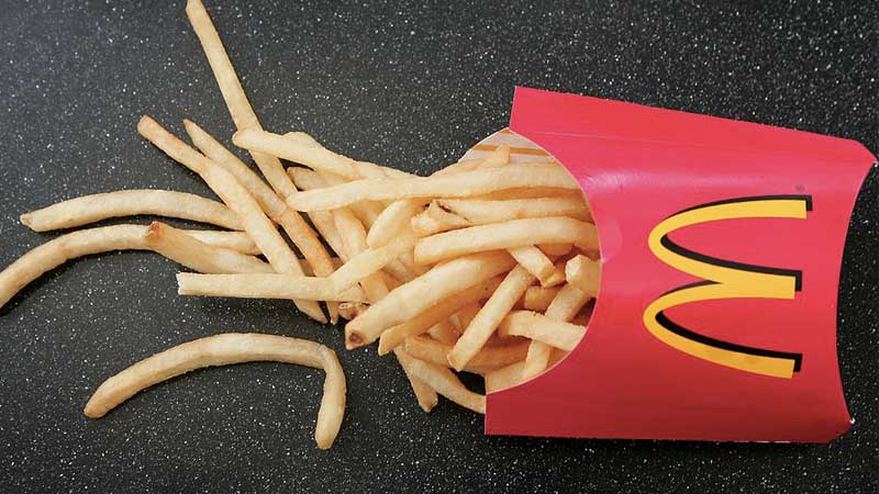 A box of McDonald's fries spilling out onto a table