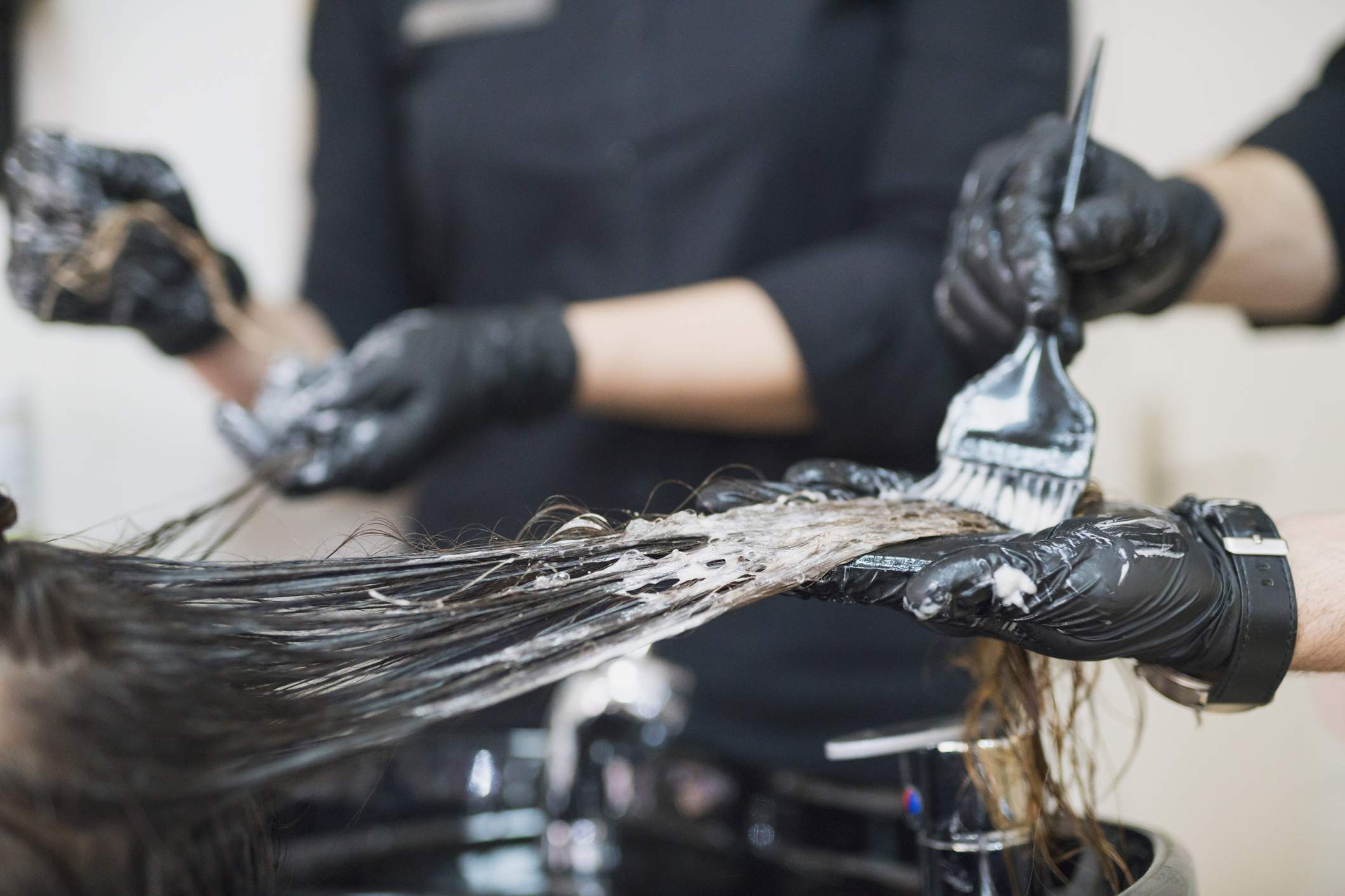 A hairdresser works on a customers colour