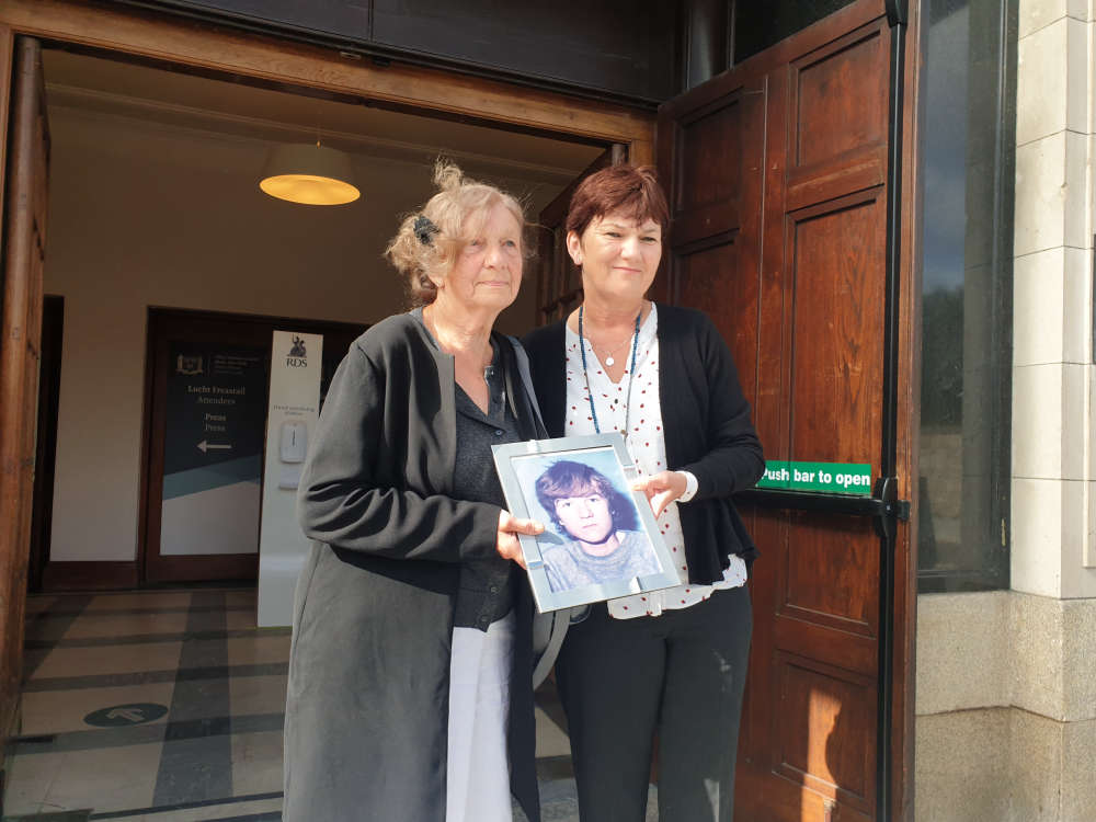 Gertrude Barrett holds a photo of her son and Stardust victim, Michael, alongside her daughter Carol.