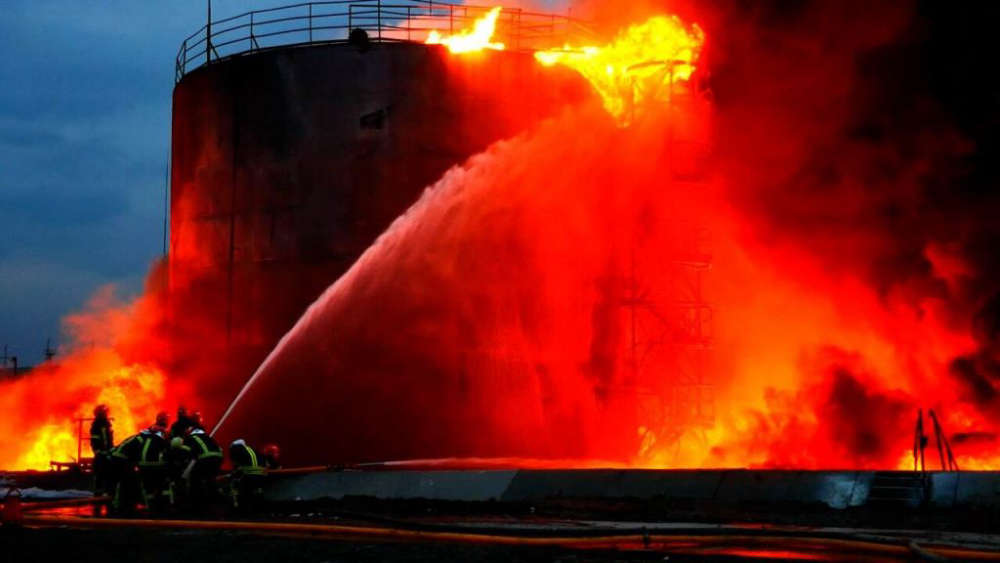 Firefighters try to extinguish the fire as the flames and smoke rise after Russian guided missiles hit fuel tanks attacks as Russian attacks continue on Ukraine, in the western Ukrainian city of Lviv