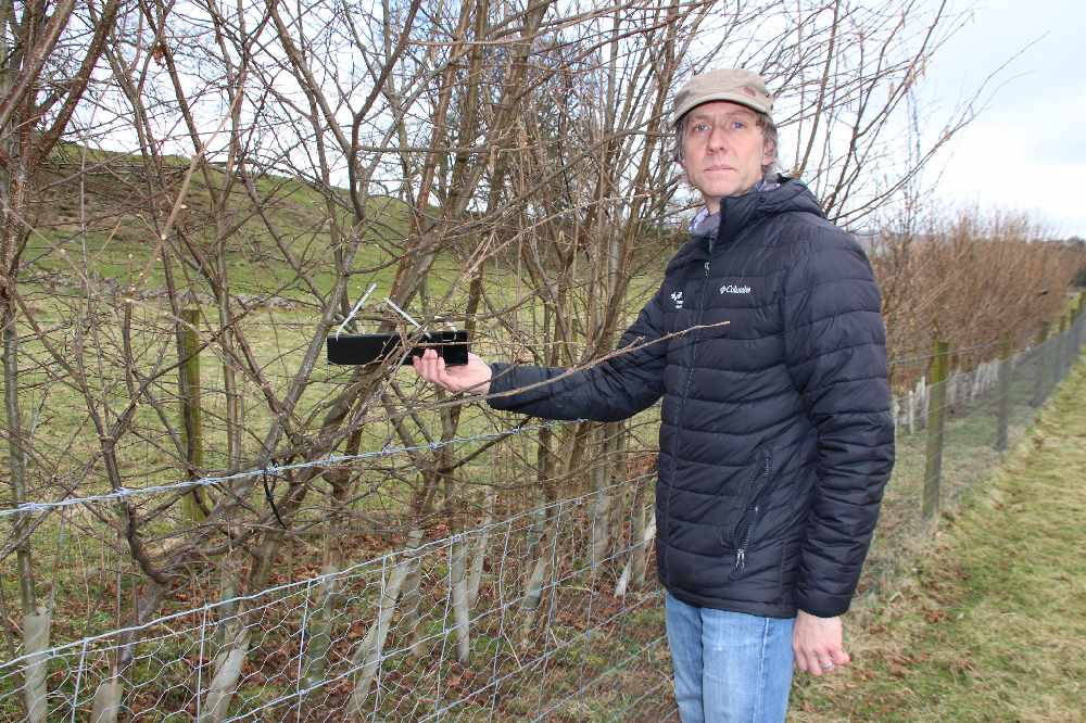 1. Phill Hibbs by one of the new hedgerows, with a tube that will be used to monitor the presence of dormice